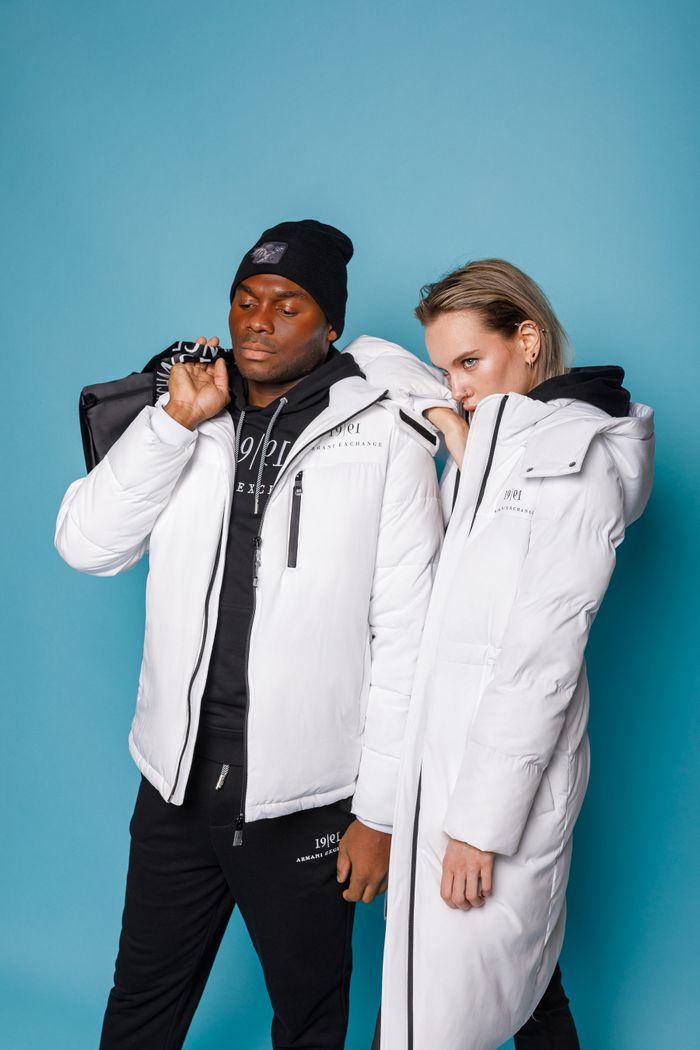 Services-03 A fashionable man and woman in white jackets against a bright blue background.