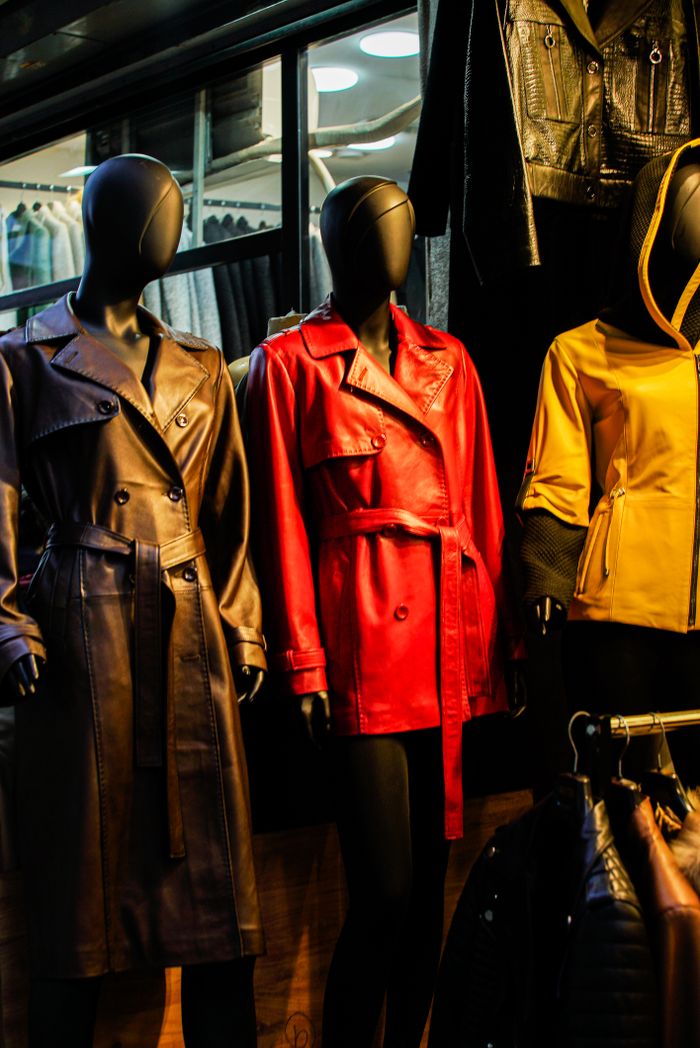 Services-01 Colorful leather coats on mannequins in a stylish window display.